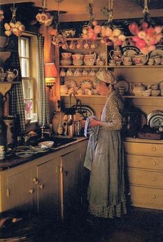 an old woman is standing in the kitchen with her tea kettles on the stove