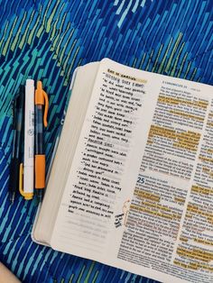 an open bible with markers and pens on it