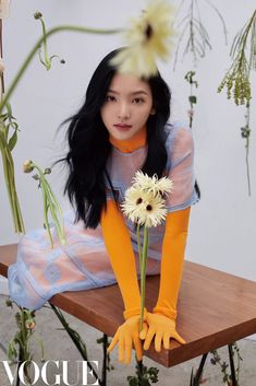 a woman sitting on a bench holding a flower