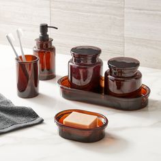 bathroom accessories including soap dispenser, soap dish and toothbrush holder on marble countertop