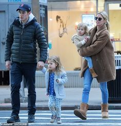 a man, woman and child crossing the street