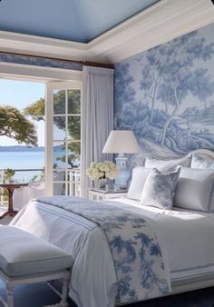 a bedroom with blue and white decor on the walls, along with a large window