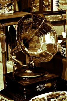 an old fashioned record player sitting on top of a table next to other antique items