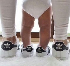 two people wearing adidas shoes standing next to each other