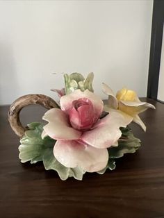 a vase with flowers sitting on top of a wooden table