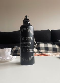 a black water bottle sitting on top of a white table