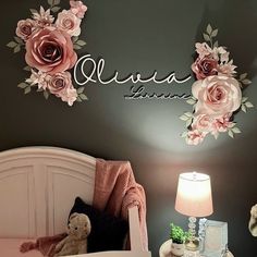 a bed room with a teddy bear and flowers on the wall