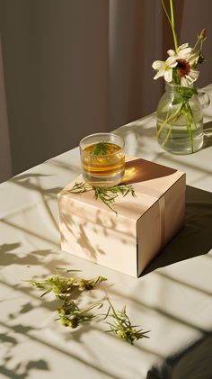 A vase of flowers sitting on a table beside a glass of tea, encased in a wooden box. A Vase Of Flowers, Vase Of Flowers