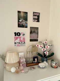 a white dresser topped with pictures and flowers