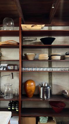 the shelves are filled with dishes and bowls