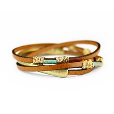 three different colored leather bracelets with gold accents