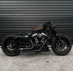 a black motorcycle parked in front of a garage door