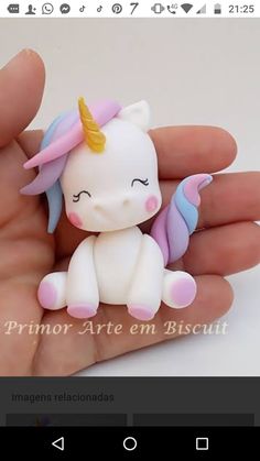 a small toy unicorn sitting on top of someone's hand