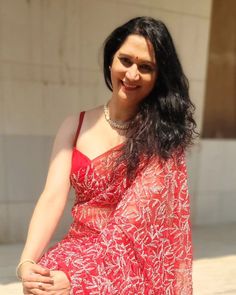 a woman in a red dress sitting on the ground