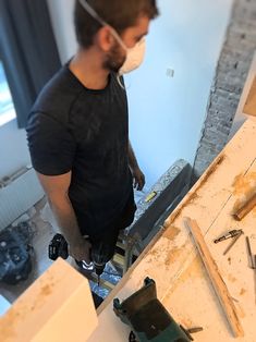 a man wearing a face mask while standing in front of a workbench and tools