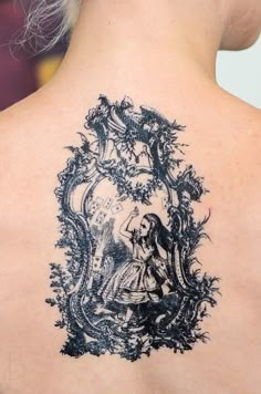 a woman's back with a tattoo on it