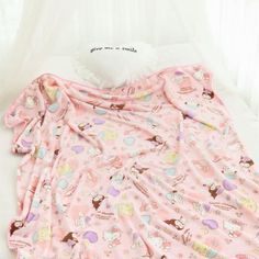 the pink pajamas are all over the bed and on top of it is a teddy bear