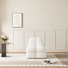 a white couch sitting on top of a wooden floor next to a vase filled with flowers