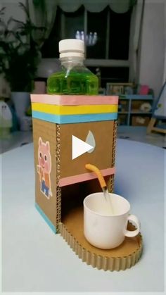 a cup is sitting in front of a box with a video player on the side