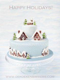 a three tiered cake decorated with houses and trees