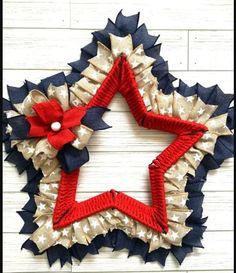 a red, white and blue wreath with stars on it is hanging on a wall