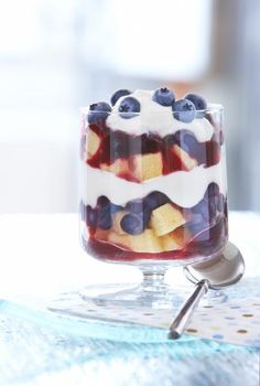 a trifle with blueberries and cream in a glass dish