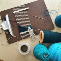 two skeins of yarn sitting on top of a table next to some scissors