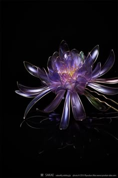 a large purple flower sitting on top of a black surface