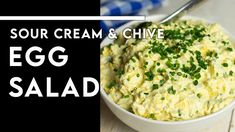 an egg salad in a white bowl with a spoon on the side and text overlay that reads sour cream & chive egg salad