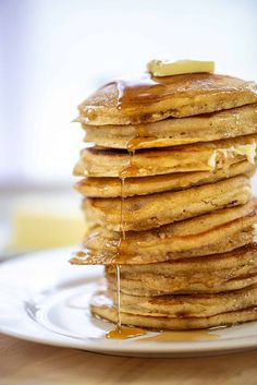 a stack of pancakes on a plate with syrup