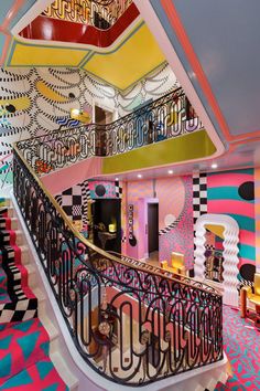 an artisticly designed staircase in a brightly colored room with black and white checkered flooring