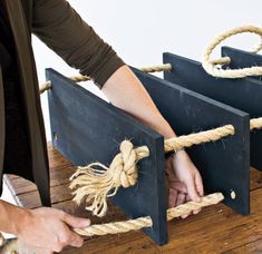 two people are pulling rope from the top of a wooden box with ropes attached to it