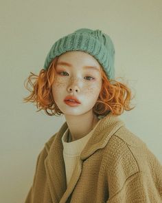 a woman with freckled hair wearing a green hat