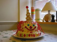 there is a cake that looks like a clown hat on the table with other decorations behind it