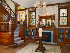 a living room filled with lots of furniture and stained glass windows next to a fire place