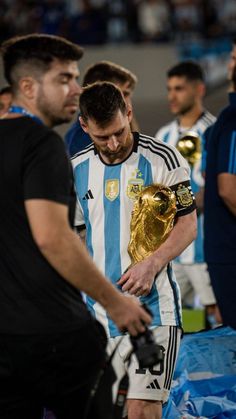 the soccer players are getting ready to play with their trophy in front of each other