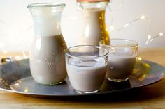 three glasses and two jugs of milk on a tray