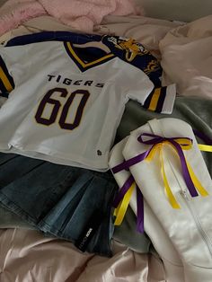 a sports jersey and skirt laying on top of a bed next to a pair of shoes