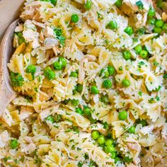 a bowl filled with pasta, peas and chicken