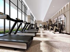 there are many treadmills lined up in the gym area with windows on both sides