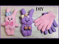 two pink and one purple bunny mittens are sitting next to each other on a table