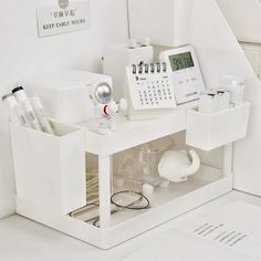 a white desk with various items on it and a clock in the corner next to it