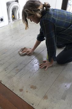 a woman kneeling down on the floor with her hands