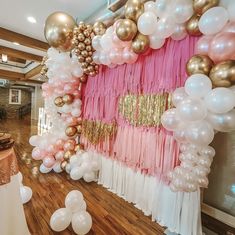 a room filled with balloons and streamers on the wall next to a wooden floor