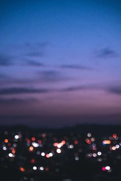 blurry city lights at night from the top of a hill with no people on it