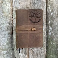 a brown leather journal sitting on top of a tree