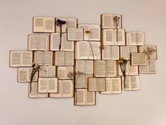 an arrangement of open books arranged in the shape of a heart with flowers on them