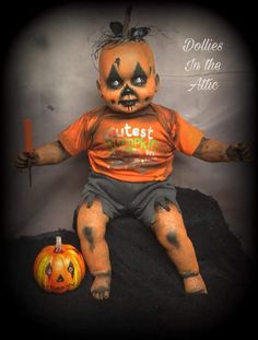 a creepy doll sitting next to a pumpkin