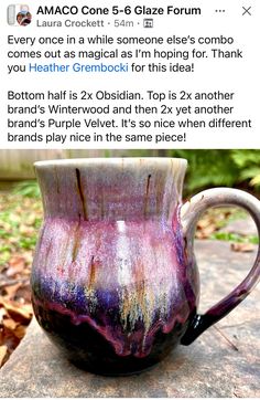 a purple and black mug sitting on top of a rock