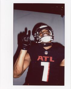 a man in a football uniform holding his hand up